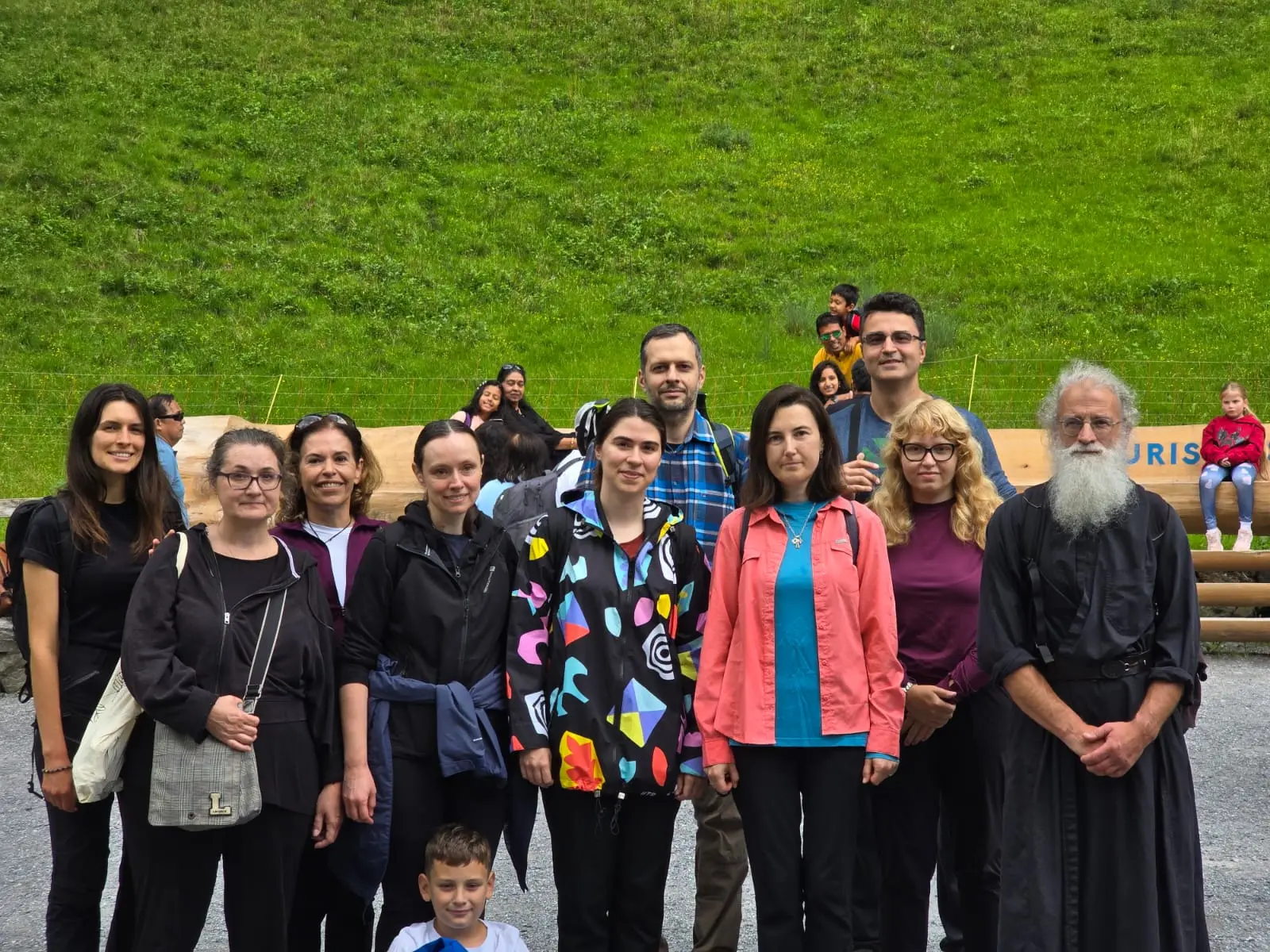 Poză de grup cu părintele pe o pajiște din valea Lauterbrunnen